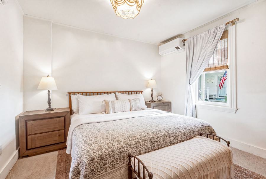 Room 10 king bed with upholstered bench and garden-facing windows