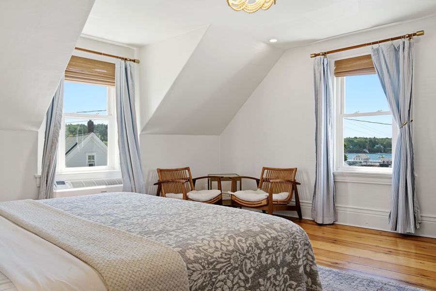 King room with two windows, seating area, and views of Boothbay Harbor.