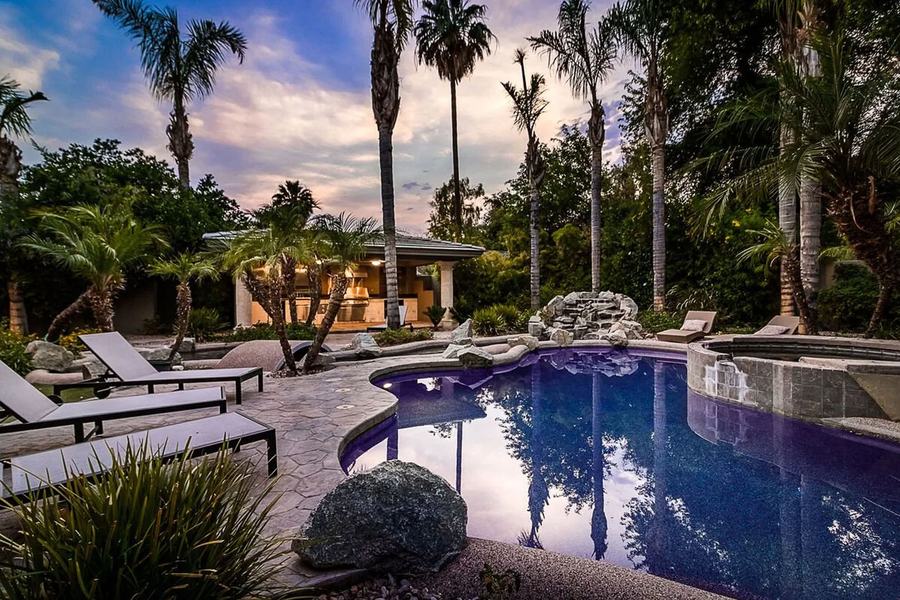 Scottsdale villa pool surrounded by palm trees at sunset