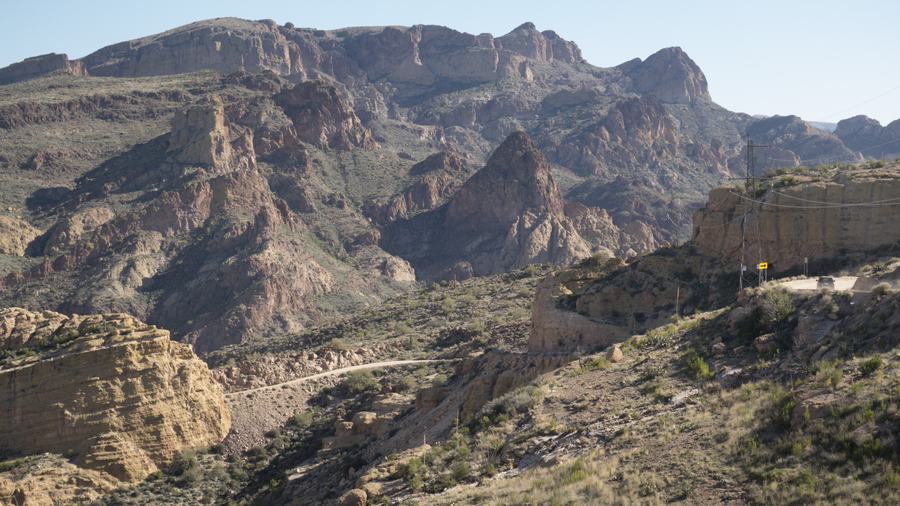 Two-lane desert highway winding through saguaro cactus toward mountains near Scottsdale