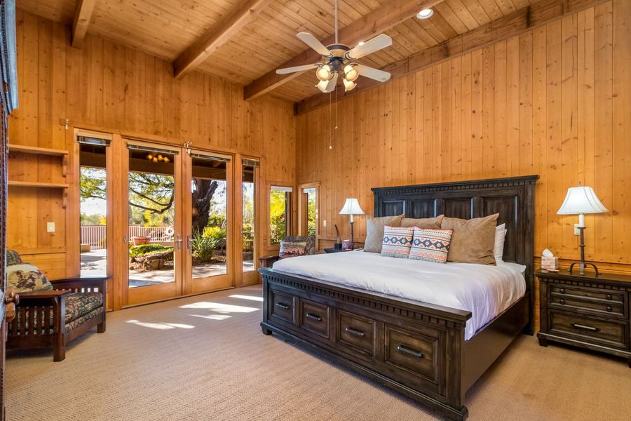 Spacious wood-paneled bedroom with king bed and garden doors