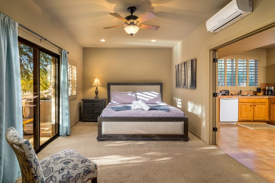 Casita bedroom with queen bed, garden doors, and adjoining kitchen