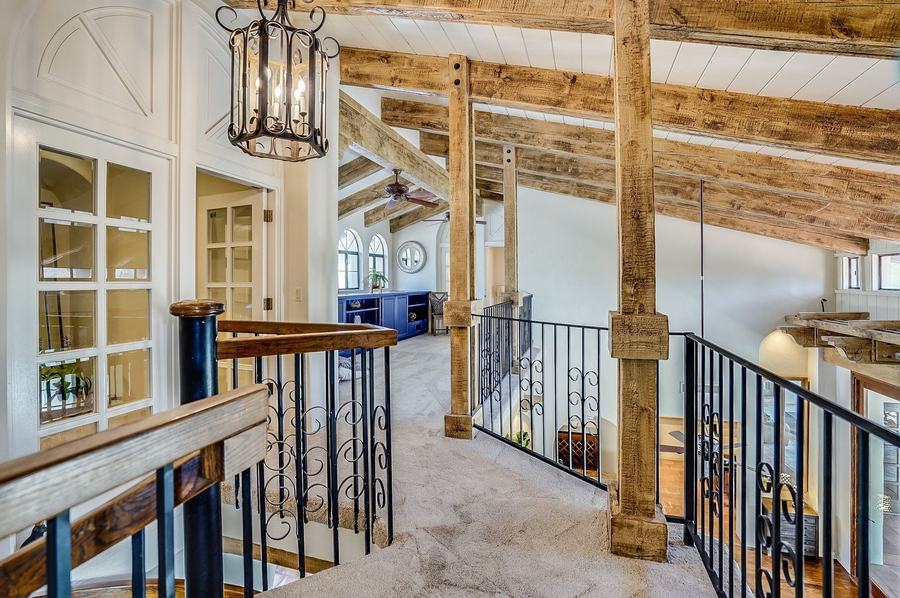 Elegant Loft Walkway with Rustic Beams & Iron Railings